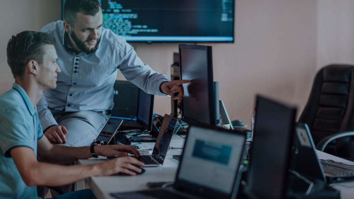 Operations team working across multiple monitors in a service environment.